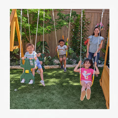 Children playing on swings and glider in a backyard