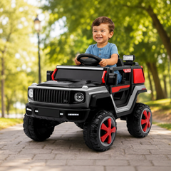 A young boy driving a black and red Mercedes-Benz style ride-on toy car with 2 seats