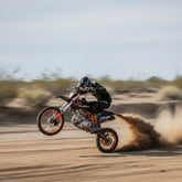 A Person riding a dirt bike on a sandy track