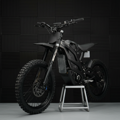 A black Ventus 1 + Off-Road Electric Dirt Bike with a visible front suspension fork and knobby tires