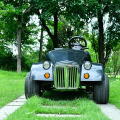 150 cc off road classic mini buggy car with a chrome grille and round headlights from the front on a grassy path.