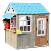 Children playing in a Kidkraft Oceanfront Wooden Outdoor Playhouse