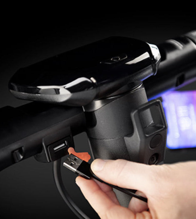 Ducati Pro III Electric Scooter with USB cable being plugged into an e-scooter power outlet.