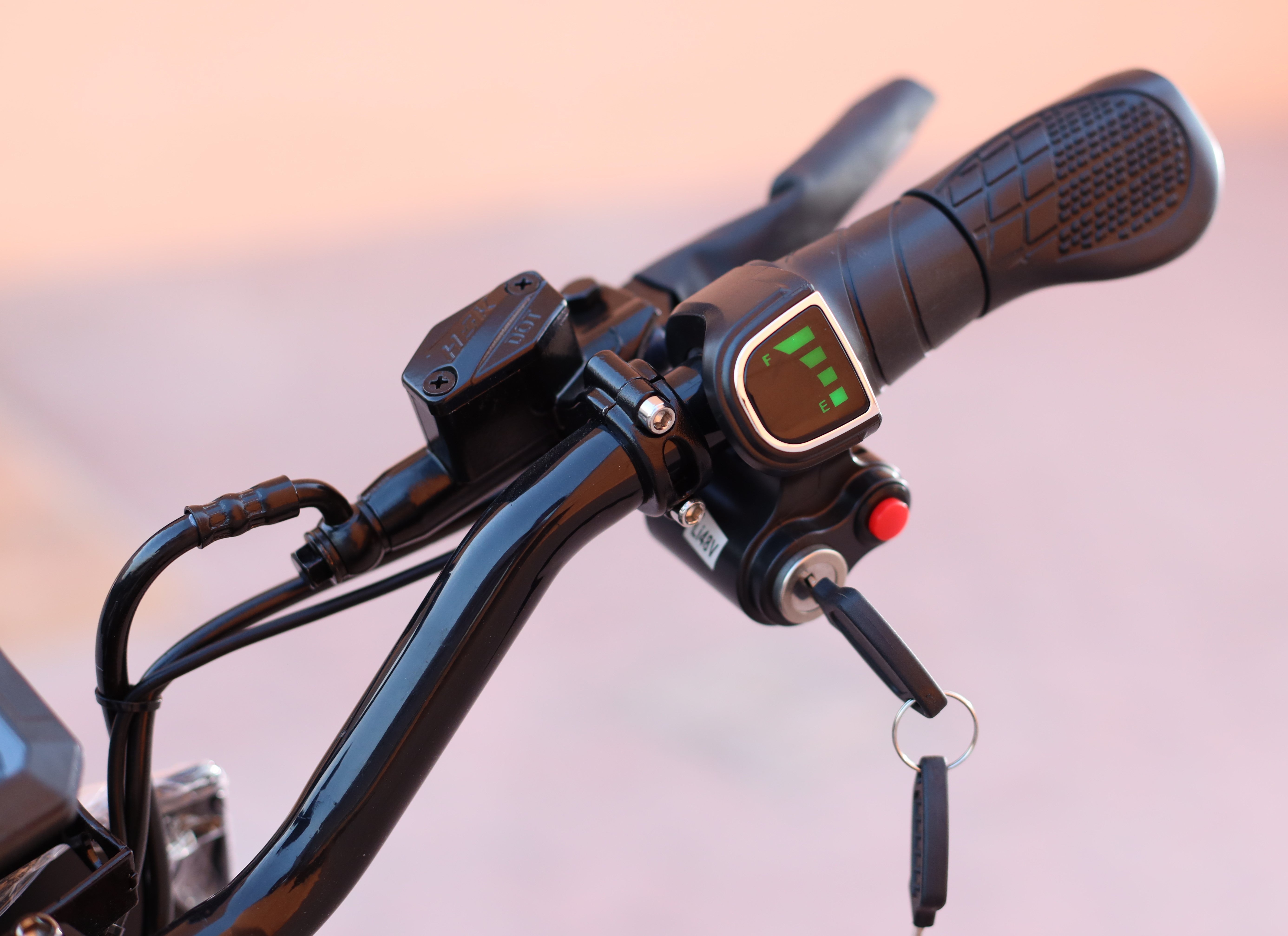 Close-up of a motorcycle handlebar with control panel and digital display