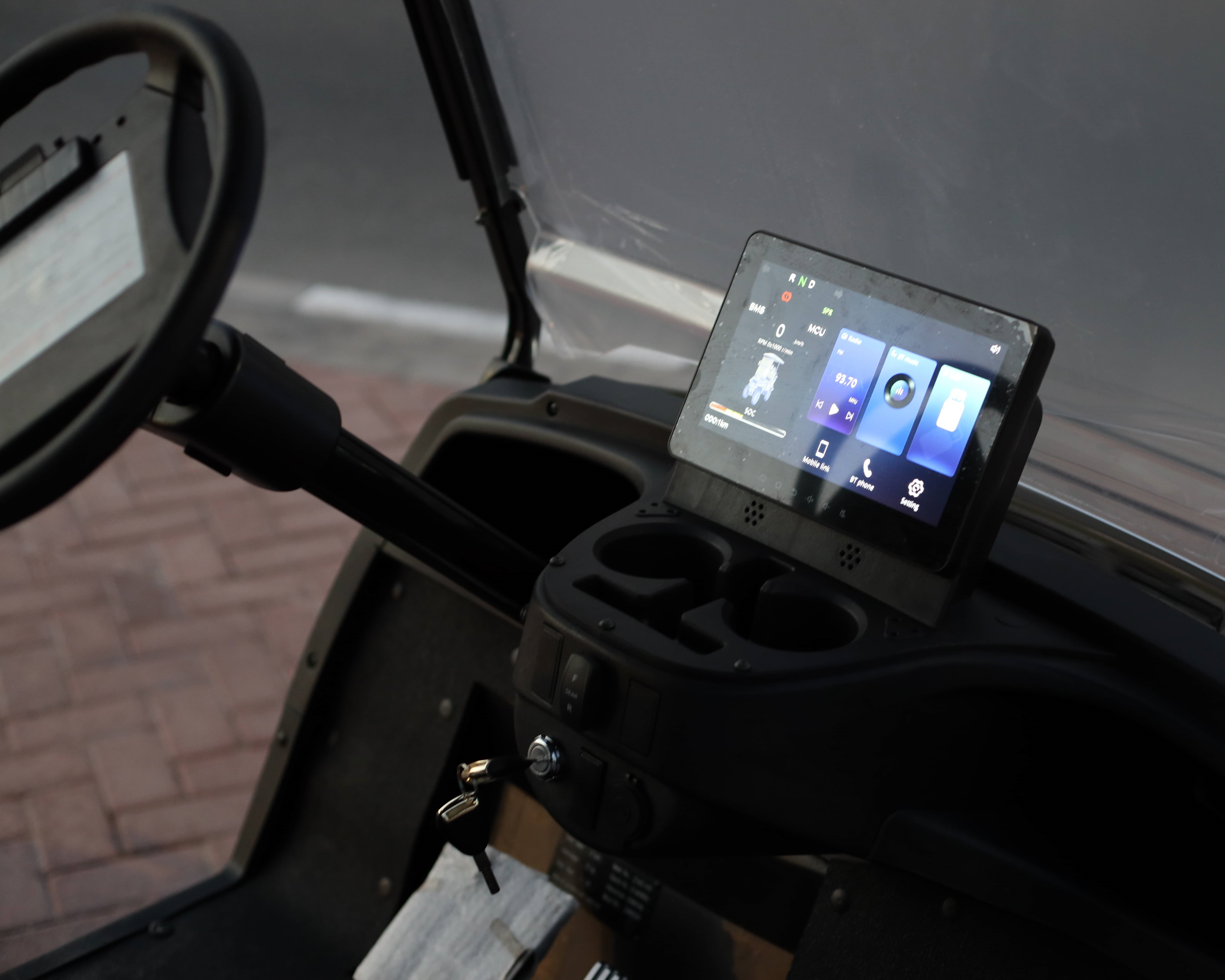 the Keon Golf cart dashboard with a touchscreen display and cup holders.