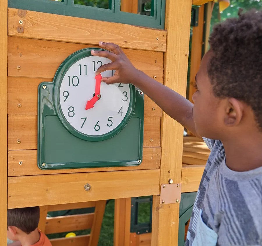 Child interacting with a clock on a Kidkraft Overland Heights 