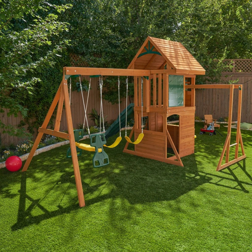 WKidKraft Ridgeview Deluxe Clubhouse Wooden playset with swings and slide on a grassy area