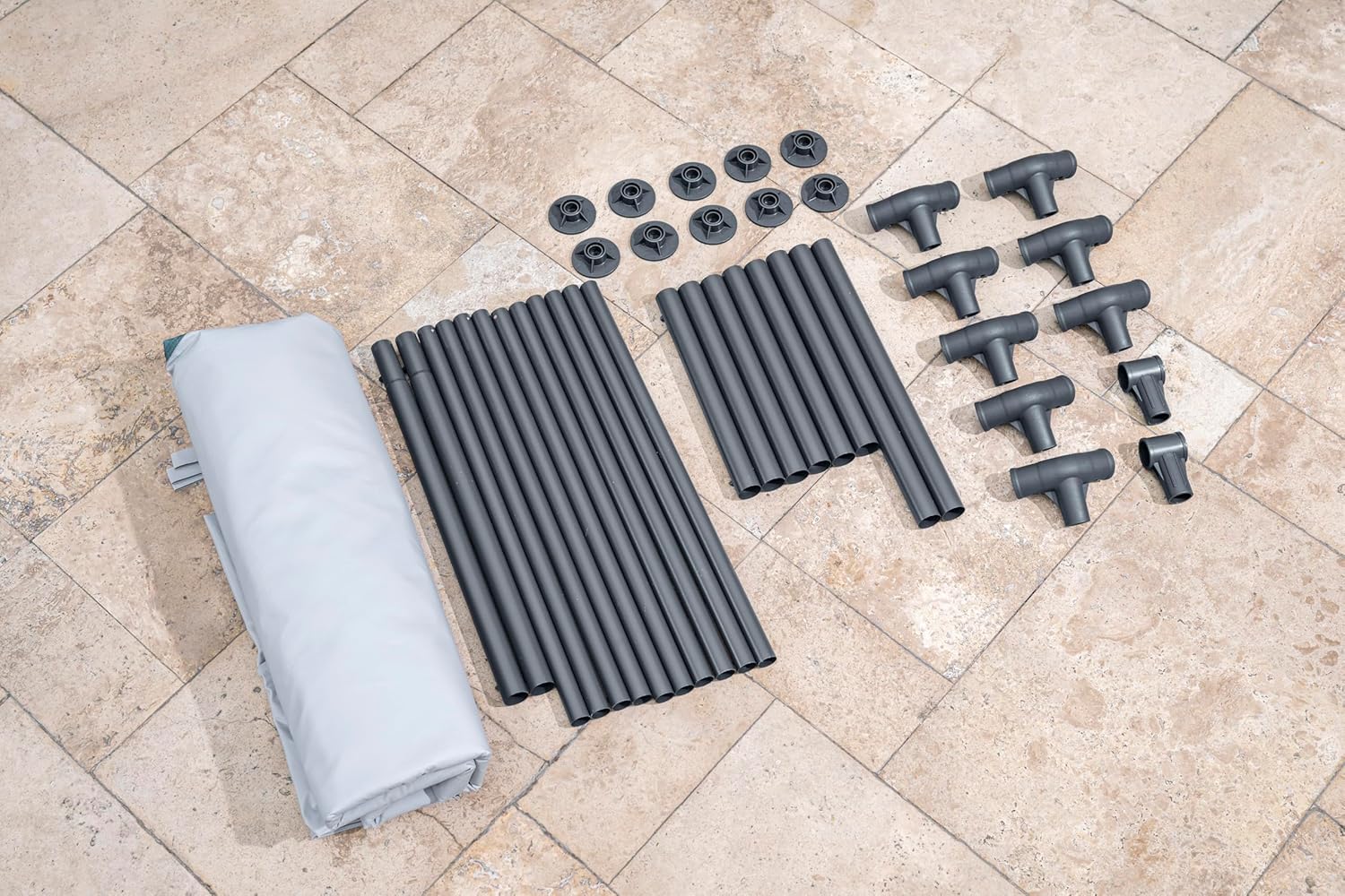 Set of black plastic components and a roll of grey material
