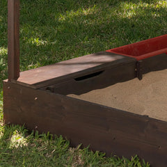 Wooden sandbox with 2 boxes and a red and brown lid on grass