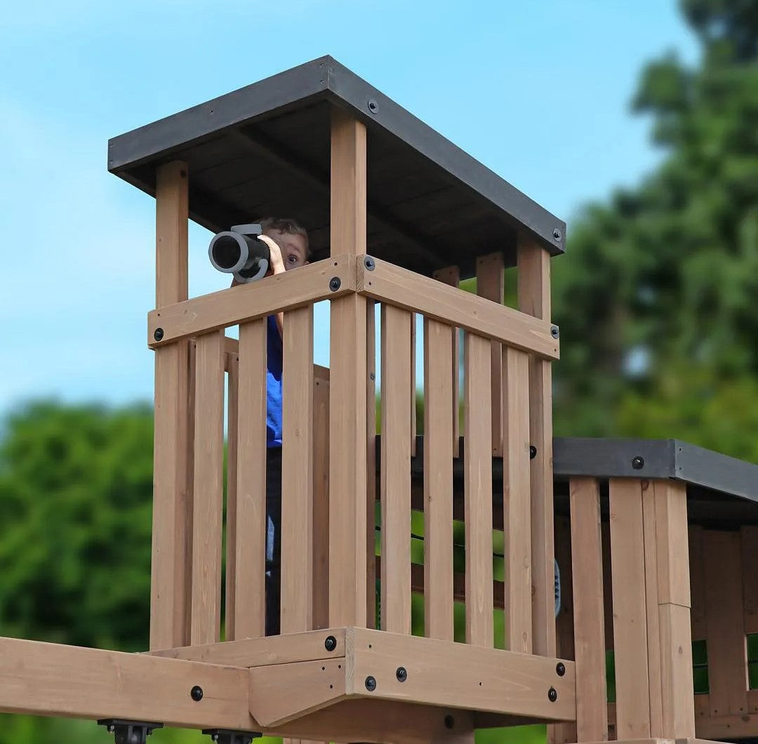 Child playing on a wooden playground structure with a telescope