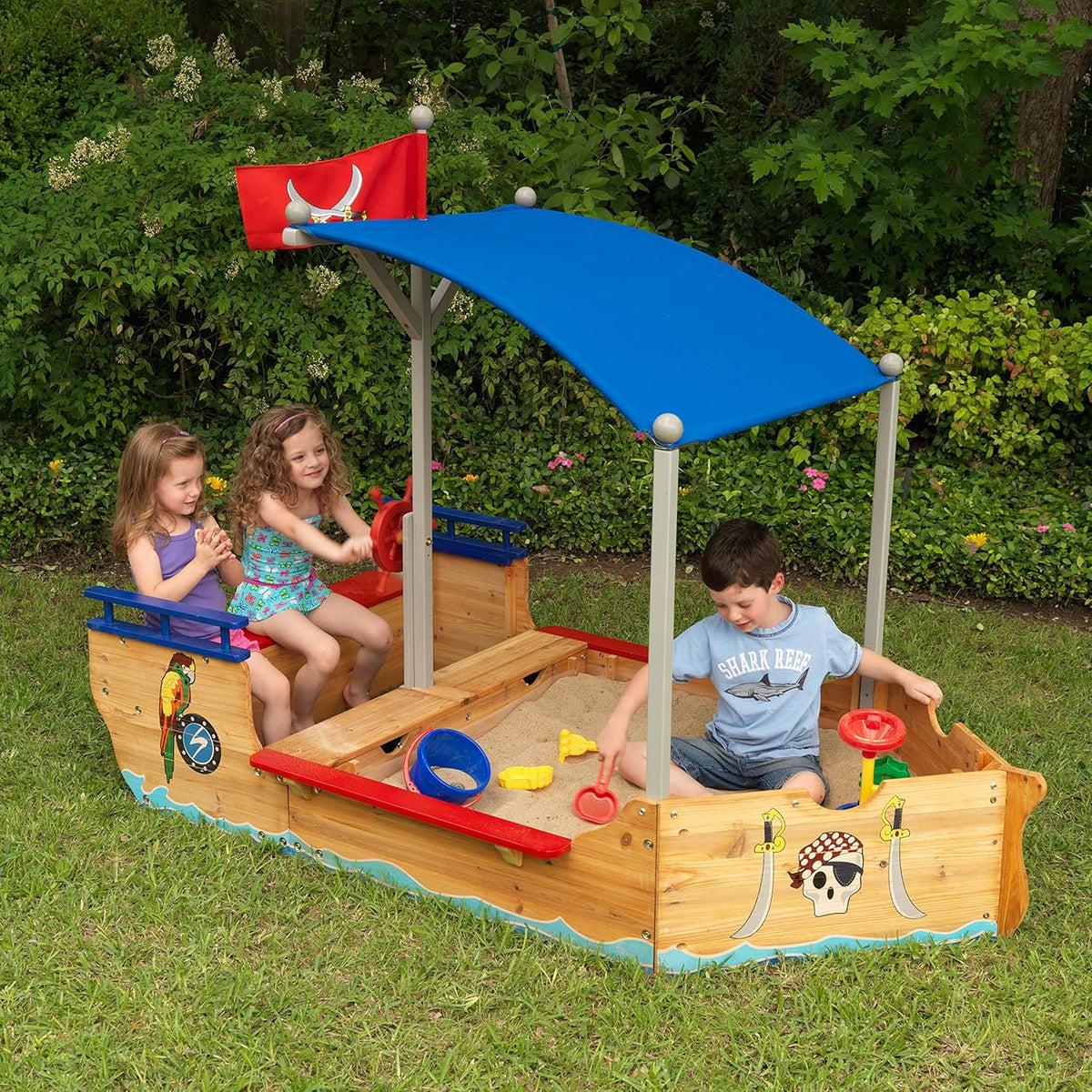 Children playing in a wooden pirate ship sandbox with a canopy