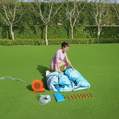 Person setting up outdoor equipment on a grassy area