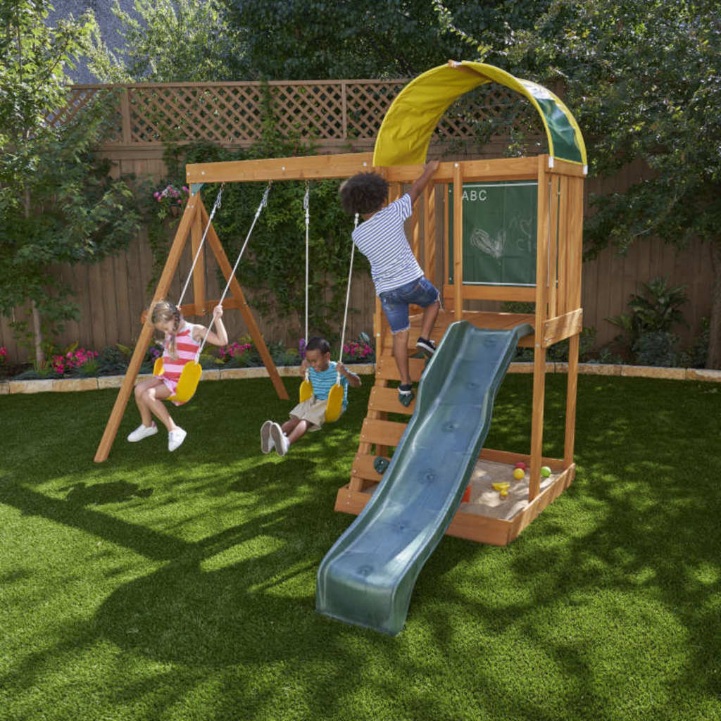 Kidkraft Ainsley Outdoor Playset Children playing on a wooden swing set with a slide in a backyard.