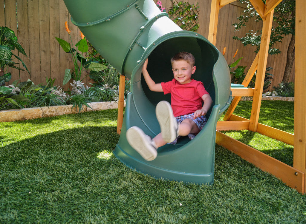 KidKraft Bear Cave Lodge Swing Set with 2 Swings and Tunnel playground slide in a backyard setting