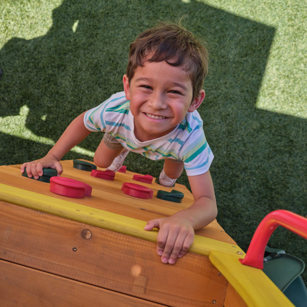 Child playing on a playground structure with a grassy background