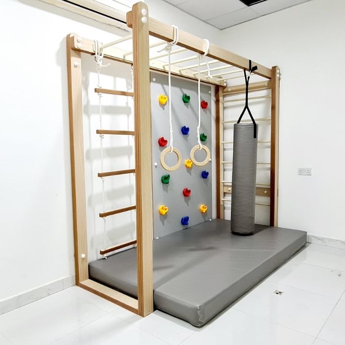 Children's play area with wooden climbing frame, colorful rings