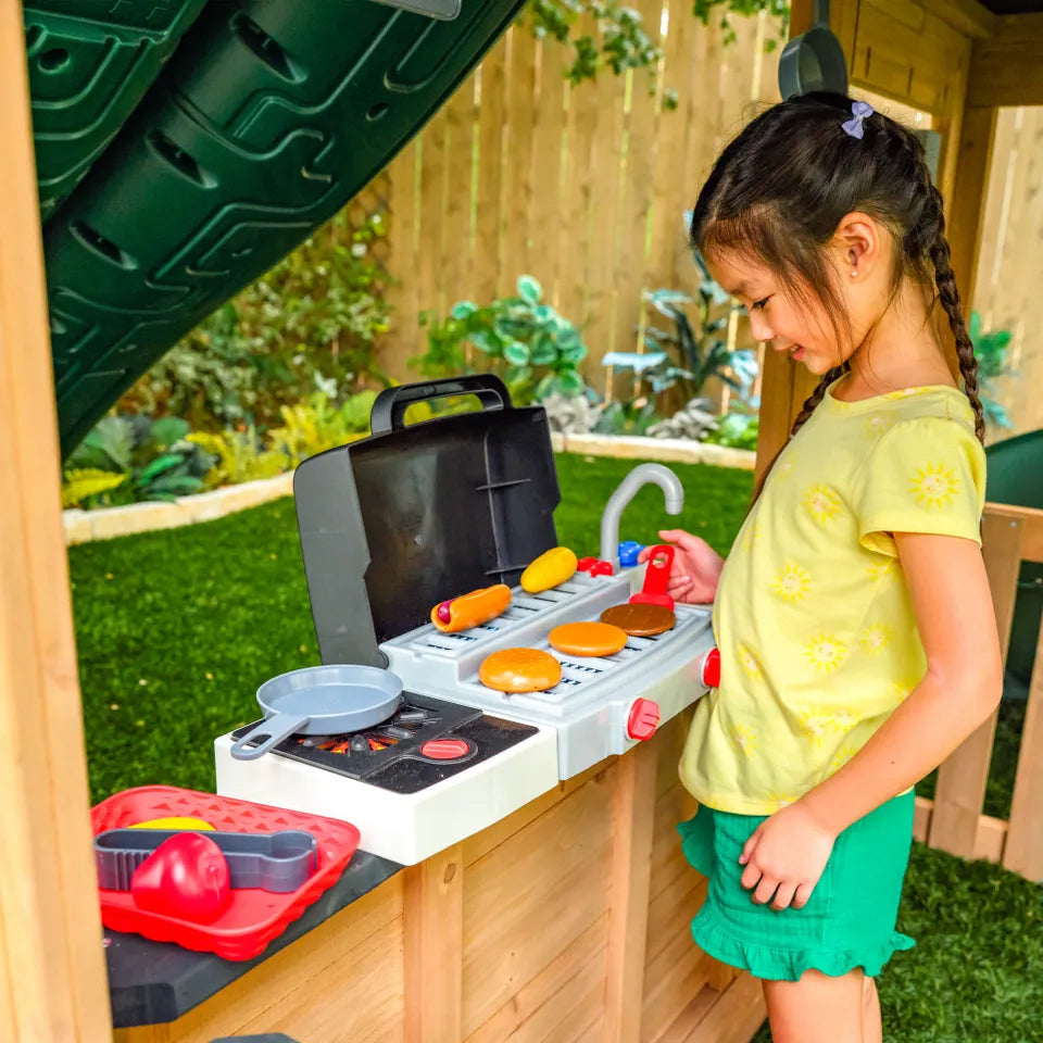 KidKraft Summit, Child playing with a toy grill set outdoors