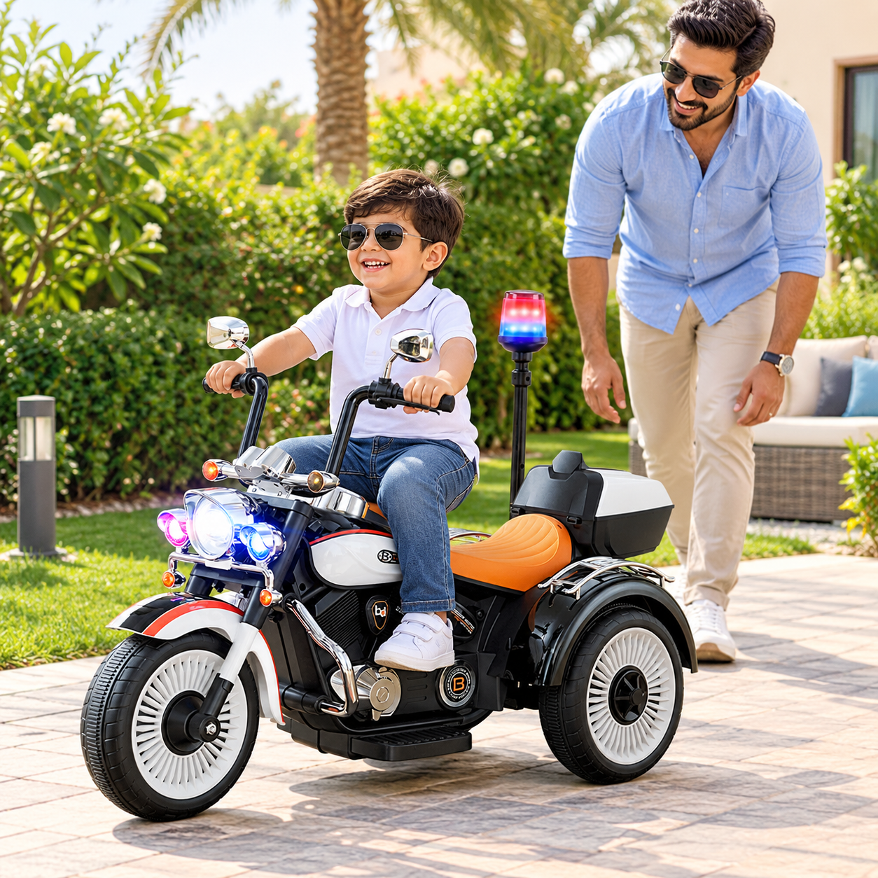 Young child riding the tricycle safely while an adult supervises nearby.