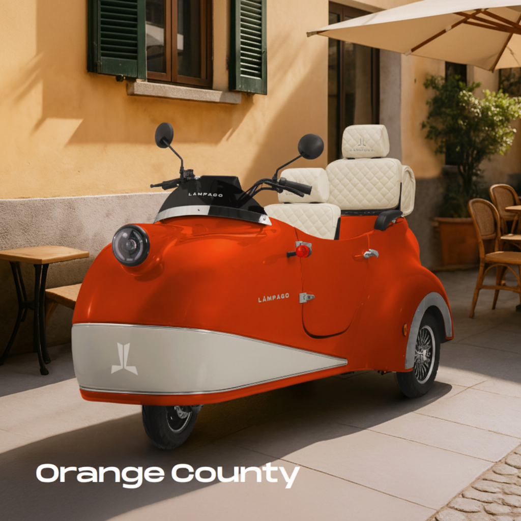 An orange and cream vintage-style three-wheeled electric vehicle with a side mirror
