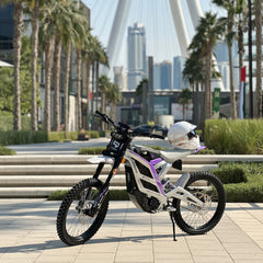 Falcon Pro Electric Dirt Bike with a helmet on a city street