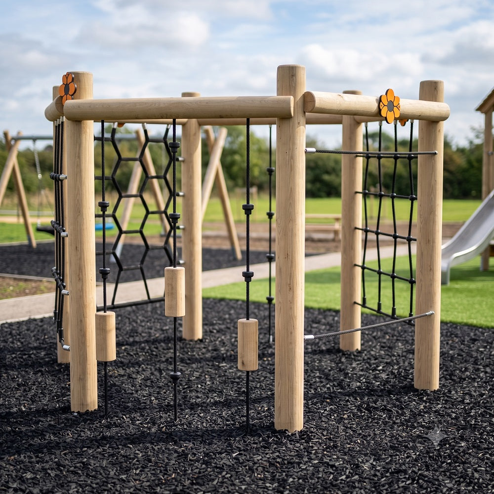 A wooden outdoor climbing gym structure with black rope nets