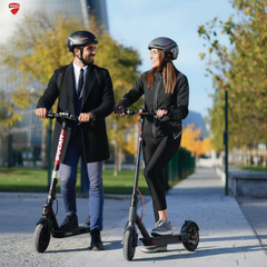 Two people riding electric scooters on a path 