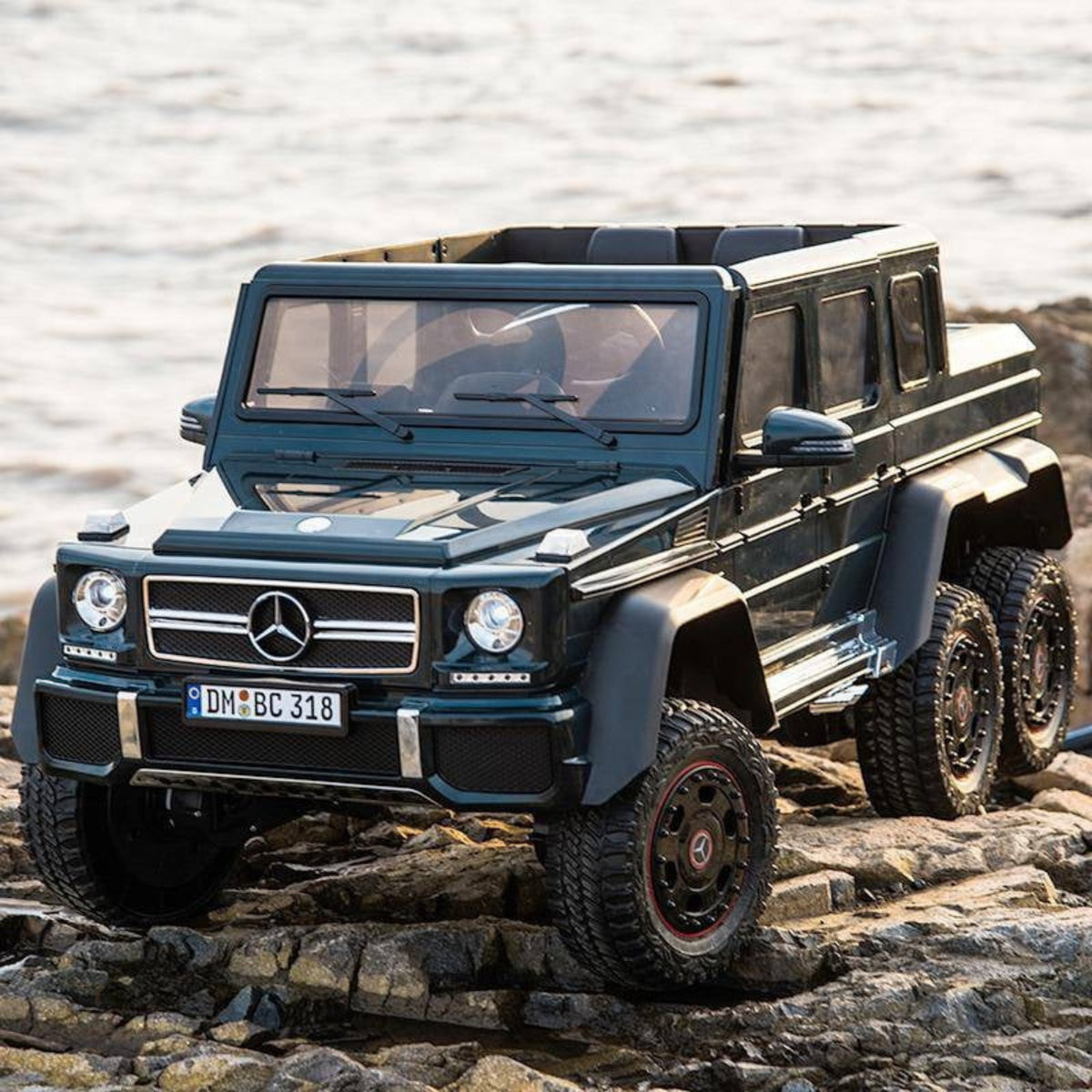 Black Mercedes-Benz G63 AMG 6x6 toy car on rocky terrain with water