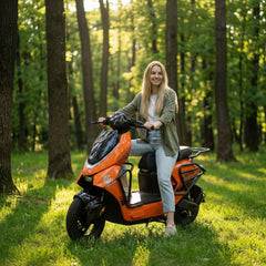 A woman sitting on an orange Electric scooter in a forest