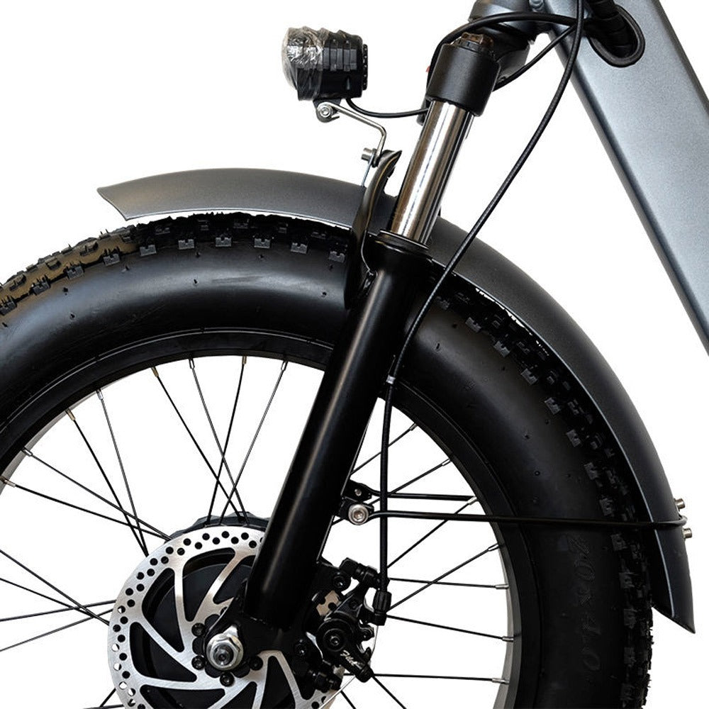 Close-up of a bicycle wheel with a black tire and suspension fork