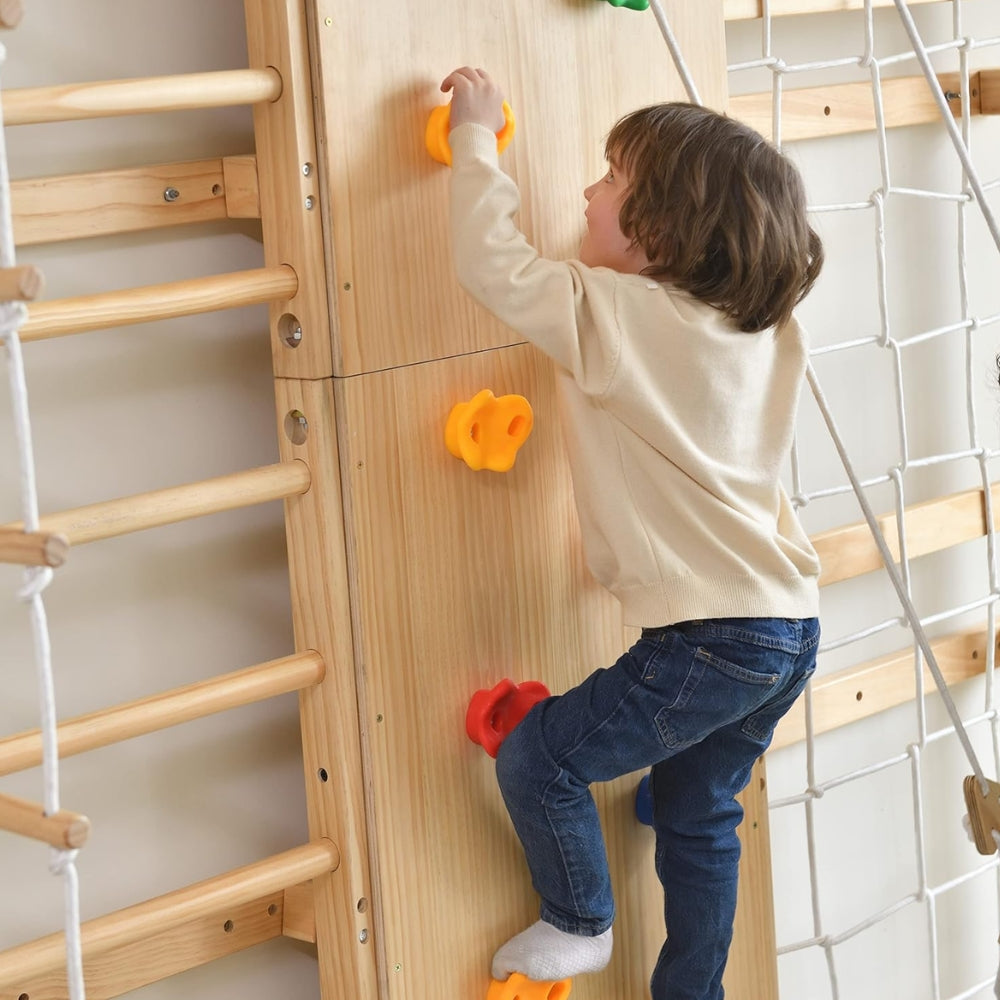 Child climbing on a wooden Swedish Ladder Wall Gym Set with colourful holds
