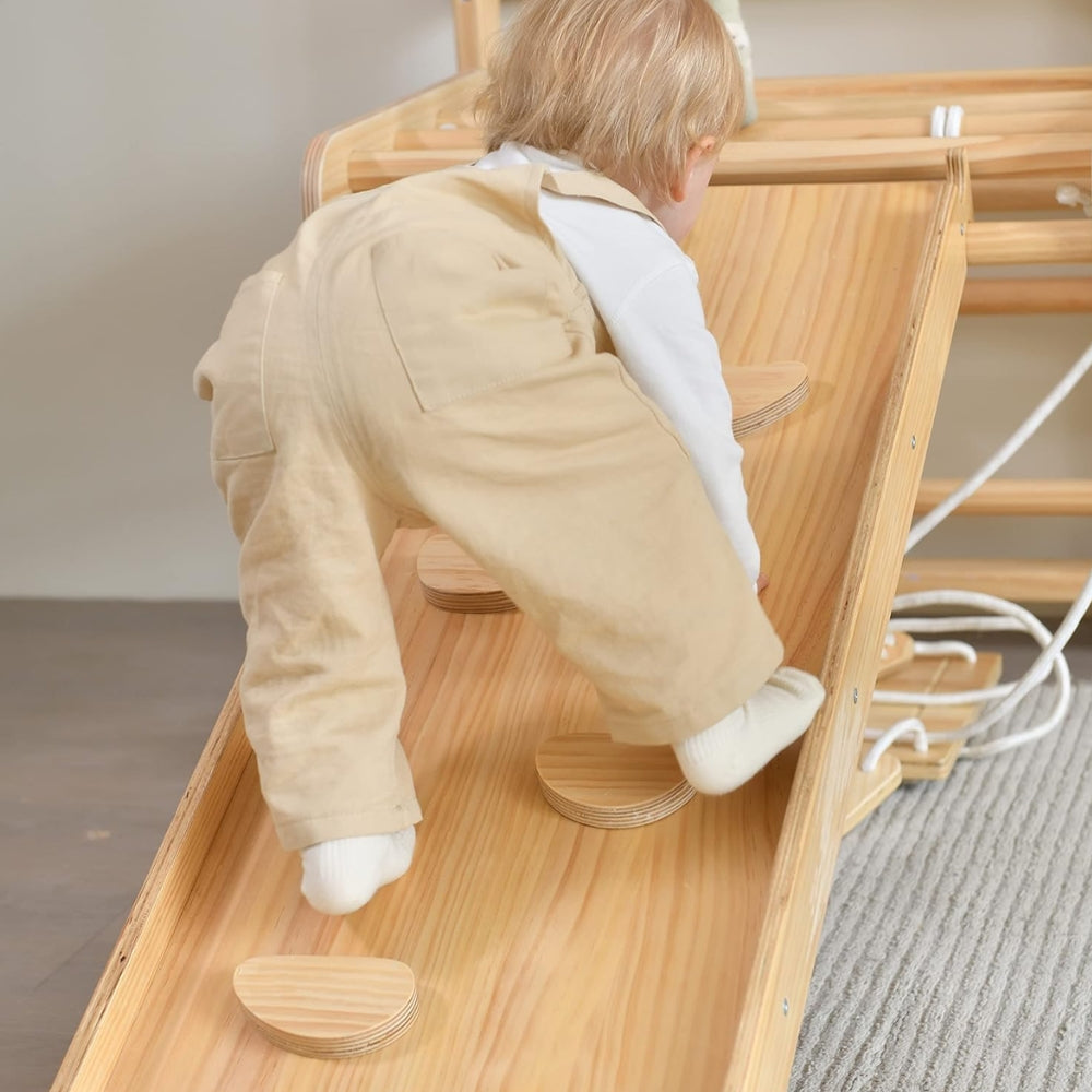 Toddler climbing a wooden indoor climbing ramp
