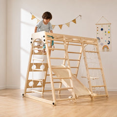 Child playing on a wooden climbing toy with a slide in a room.