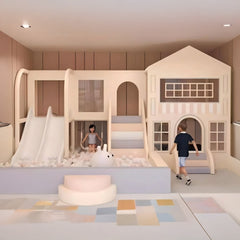 Indoor playhouse with a house-shaped climbing structure, two slides, a ball pit, and a small rug.