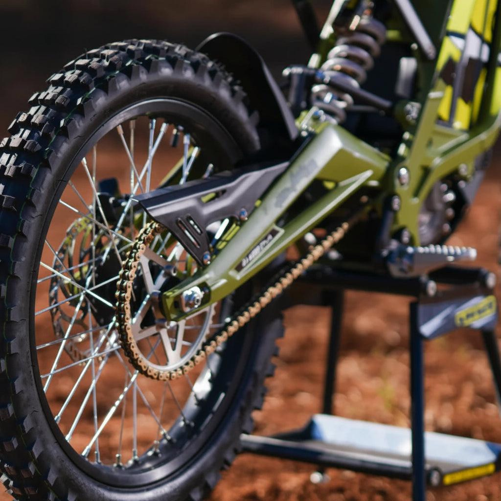 Close-up of a green dirt bike on a stand with a blurred background