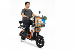 Man riding an electric scooter with a basket of groceries