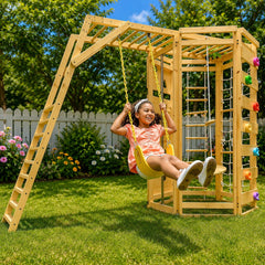 A young girl is smiling while swinging on a large wooden backyard playset 