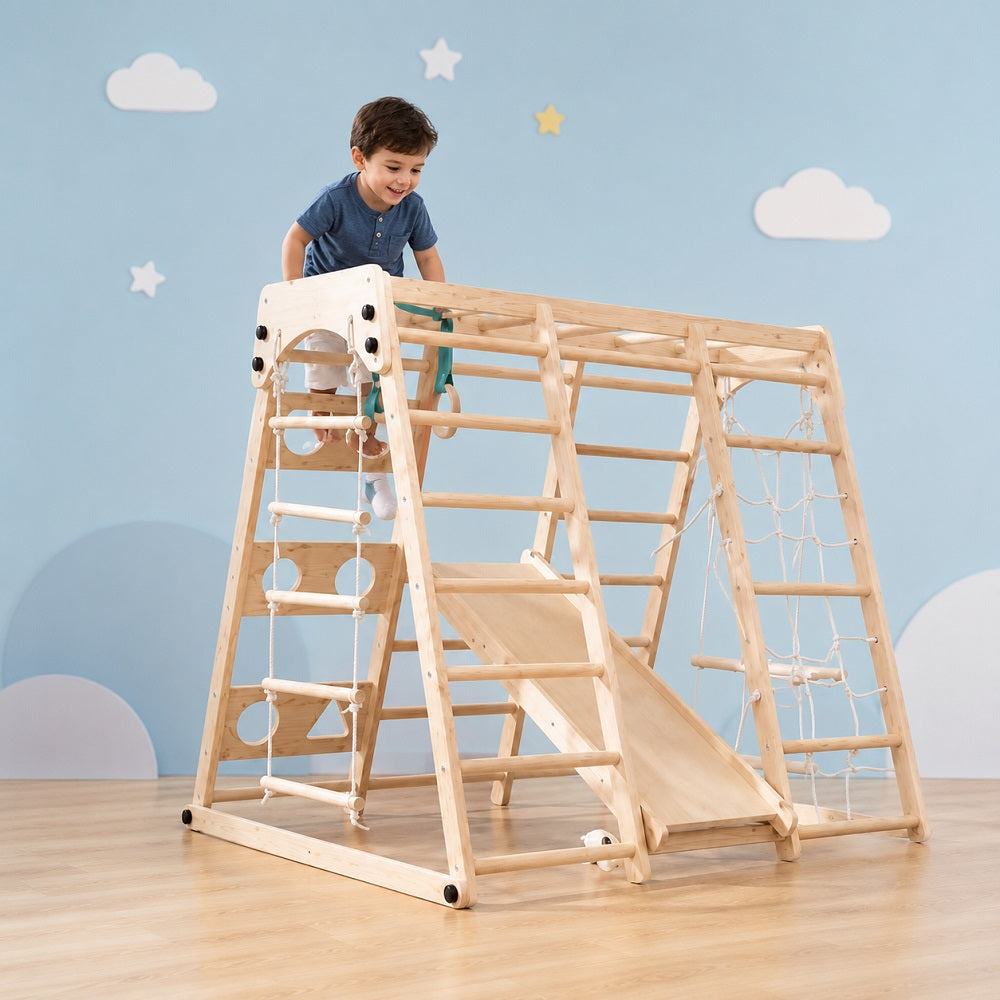 Child playing on a wooden climbing toy with a slide in a room.