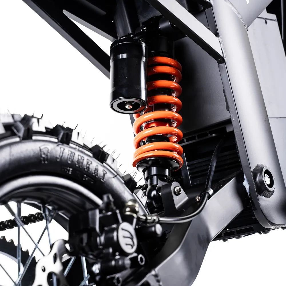 Close-up of a motorcycle suspension system spring and components.