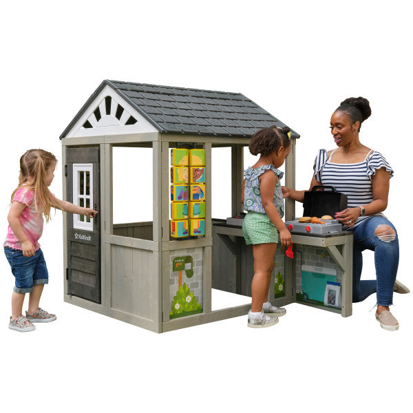 Children playing around a KidKraft Patio Party Playhouse