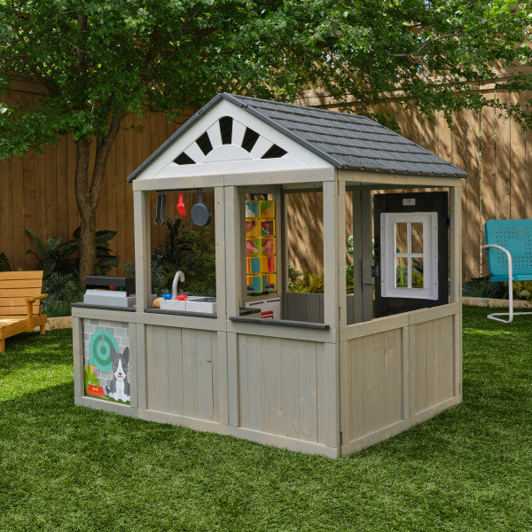 Children's playhouse with various accessories on a grassy Play area
