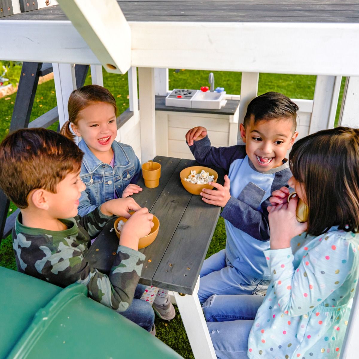 Kidkraft Wrangler Way Swing Set, Wooden Playhouse Children playing with bowls.