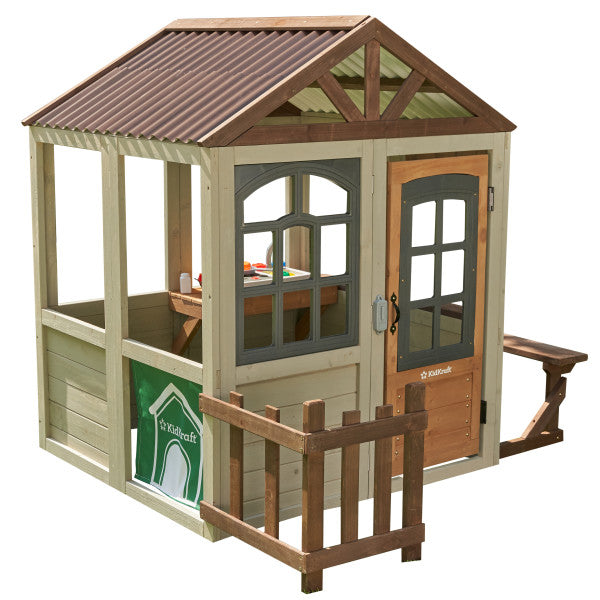 Children's playhouse with a brown roof and wooden door