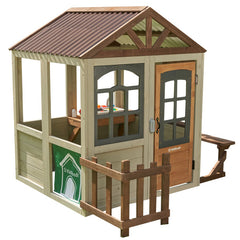 Children's playhouse with a brown roof and wooden door