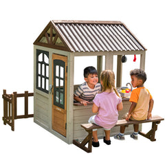 Children playing in a KidKraft Pioneer Cottage Wooden Playhouse - 149.81 x 147.5 x 140.31 cm